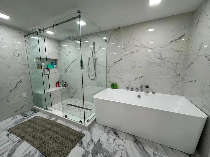 Marble bathroom with a glass shower and freestanding bathtub.