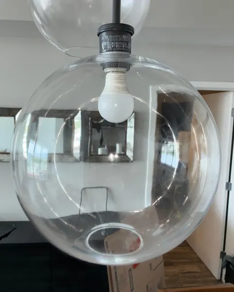 After: clear glass pendant light with a white bulb in a furnished room.