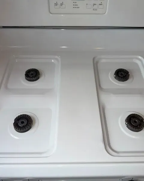 After: white gas stovetop with four exposed burners.