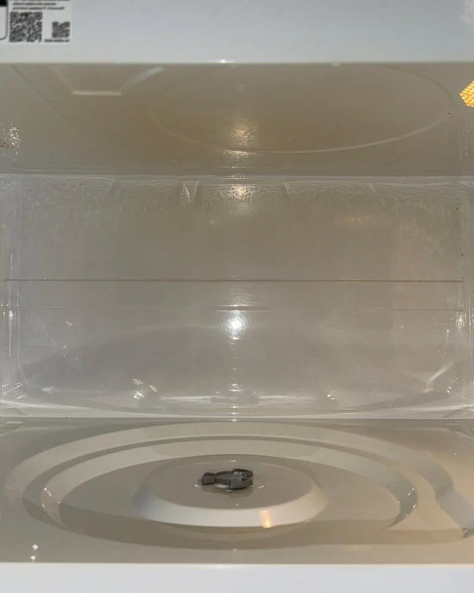 White microwave interior and turntable support with the glass plate removed.