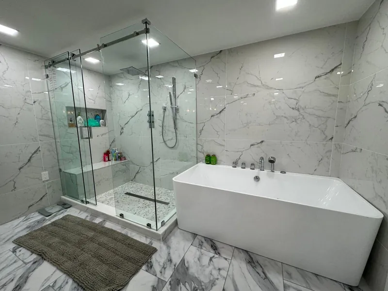 Marble bathroom with a glass shower and freestanding bathtub.